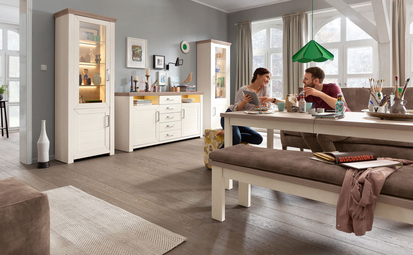 Wohnzimmer mit Esstisch, Bank und Sideboard in heller Holzoptik, seitliche Perspektive