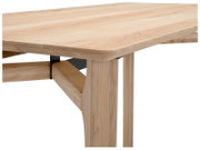 Nahaufnahme eines Schreibtisches aus hellem Holz mit Metallverstrebung, perspektivisch von der Seite aufgenommen.