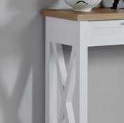 Detailansicht einer weißen Konsole mit Holzplatte und dekorativem X-Muster an der Seite.