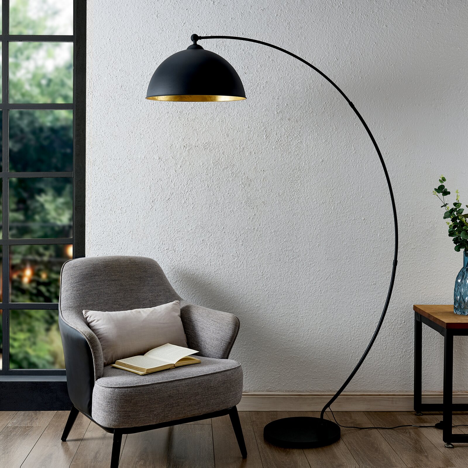 Moderne Stehleuchte mit gebogenem Arm und schwarzem Lampenschirm, seitliche Perspektive.