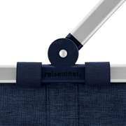 Detailfoto vanuit vooraanzicht: reisenthel boodschappenmand/draagtas in donkerblauw met aluminium handvat en scharnier, logo in het midden zichtbaar