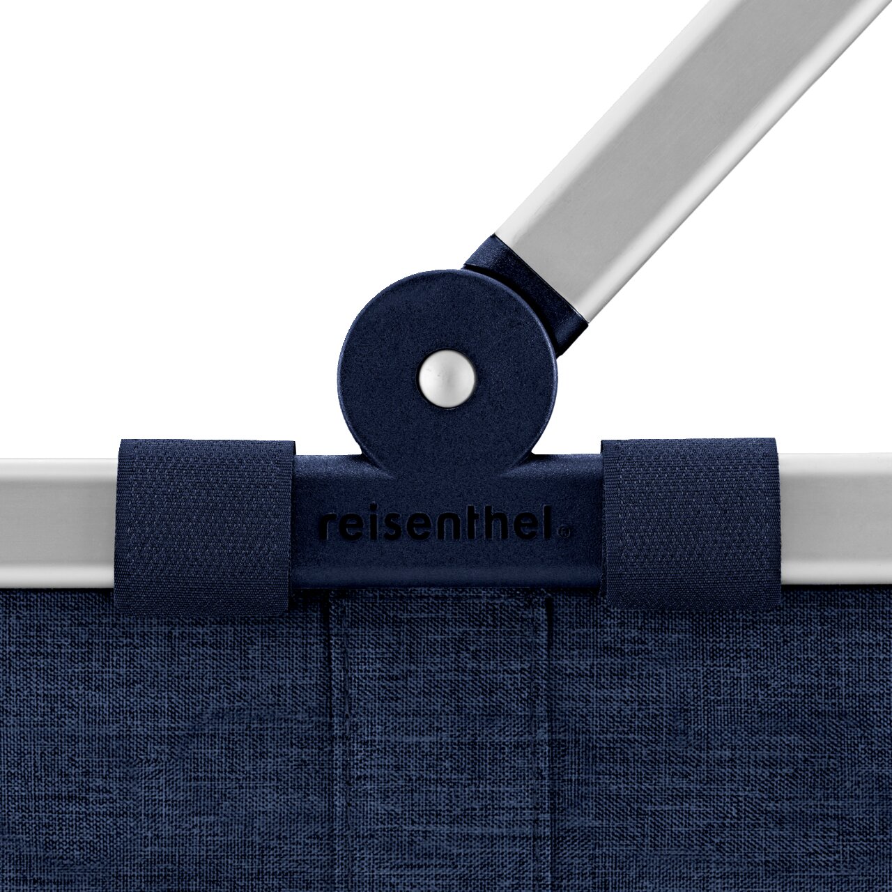 Detailfoto vanuit vooraanzicht: reisenthel boodschappenmand/draagtas in donkerblauw met aluminium handvat en scharnier, logo in het midden zichtbaar