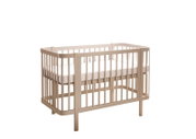 Beiges Babybett aus Holz mit Gitterseiten und weißer Matratze, freigestellt auf weißem Hintergrund, Ansicht schräg von vorne.