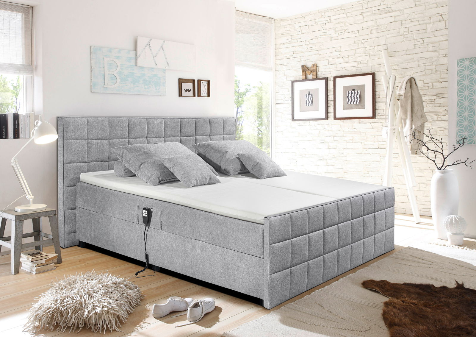 Graues Polsterbett in einem modernen Schlafzimmer, seitliche Perspektive