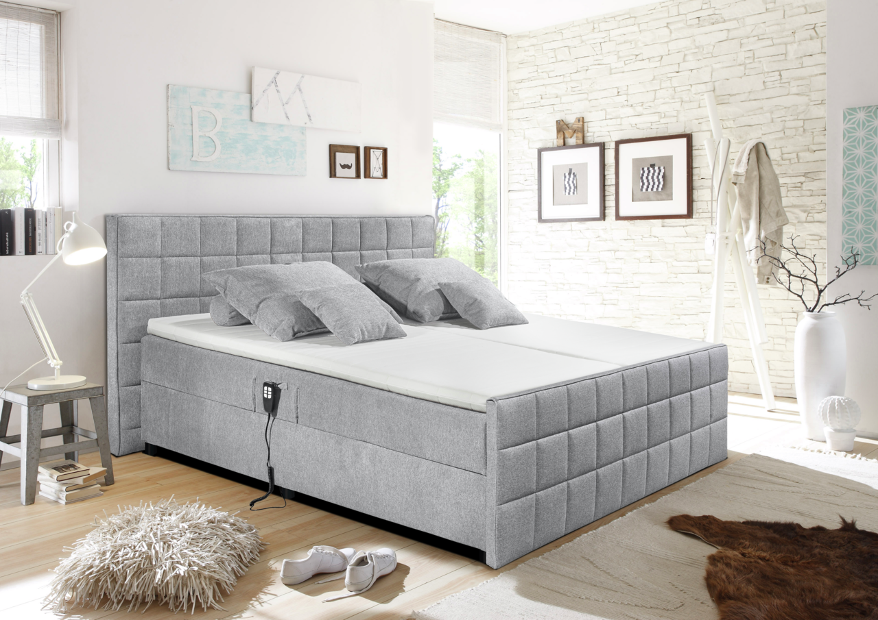 Graues Polsterbett in einem modernen Schlafzimmer, seitliche Perspektive