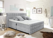 Grijs boxspringbed in een moderne slaapkamer, zijaanzicht