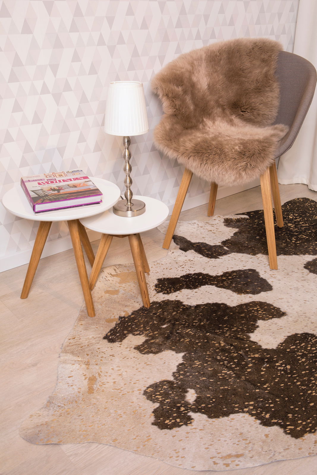 Schaffell auf einem Stuhl in einem modernen Raum mit Teppich und Beistelltischen, seitliche Perspektive