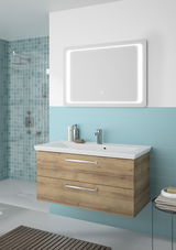 Moderner Badblock mit Holzoptik und zwei Schubladen, darüber ein beleuchteter Spiegel, seitliche Perspektive