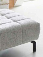 XXL-Hocker in Nahaufnahme, seitliche Perspektive, mit hellgrauem, gepolstertem Stoff und schwarzen Beinen.