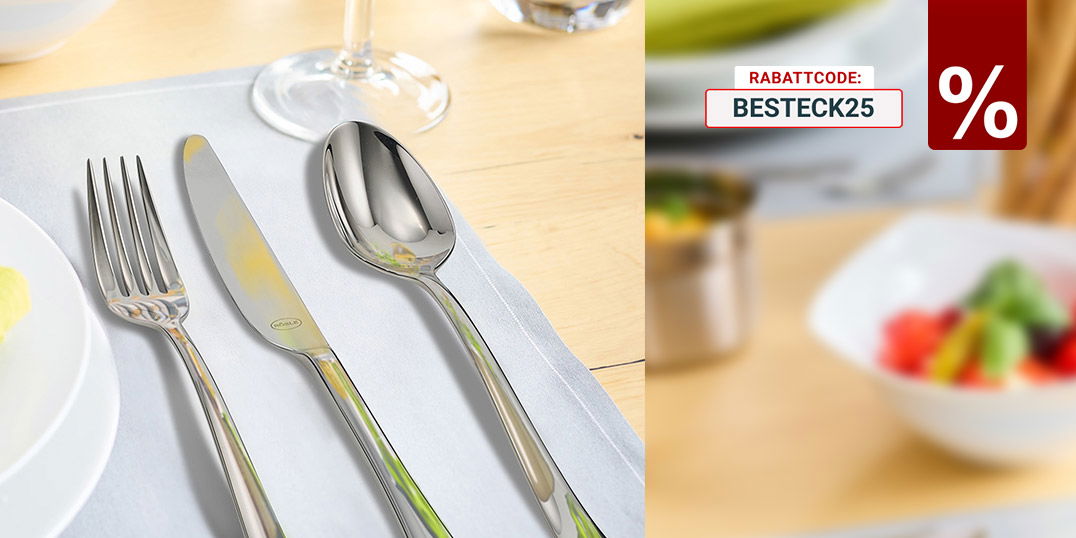 Elegant gedeckter Tisch mit Besteck, Weinglas, Teller mit grünem Stoffserviette und Schüssel mit Tomaten.