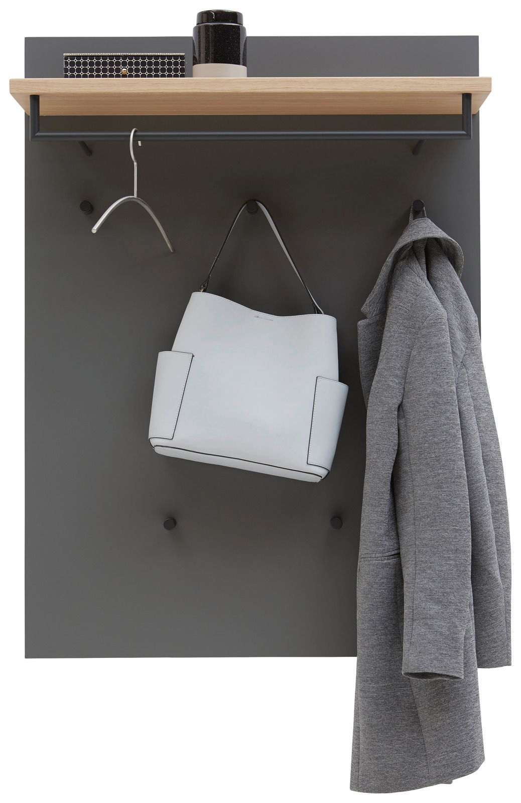 Garderobenpaneel mit grauer Rückwand, Holzablage, Kleiderstange und Haken, frontal fotografiert. Auf der Ablage stehen Dekorationsgegenstände, darunter hängt ein Kleiderbügel, eine weiße Tasche und ein grauer Mantel.