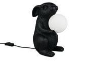 Schwarze Tischleuchte in Form eines sitzenden Hasen, der eine weiße Kugel hält, seitliche Perspektive.