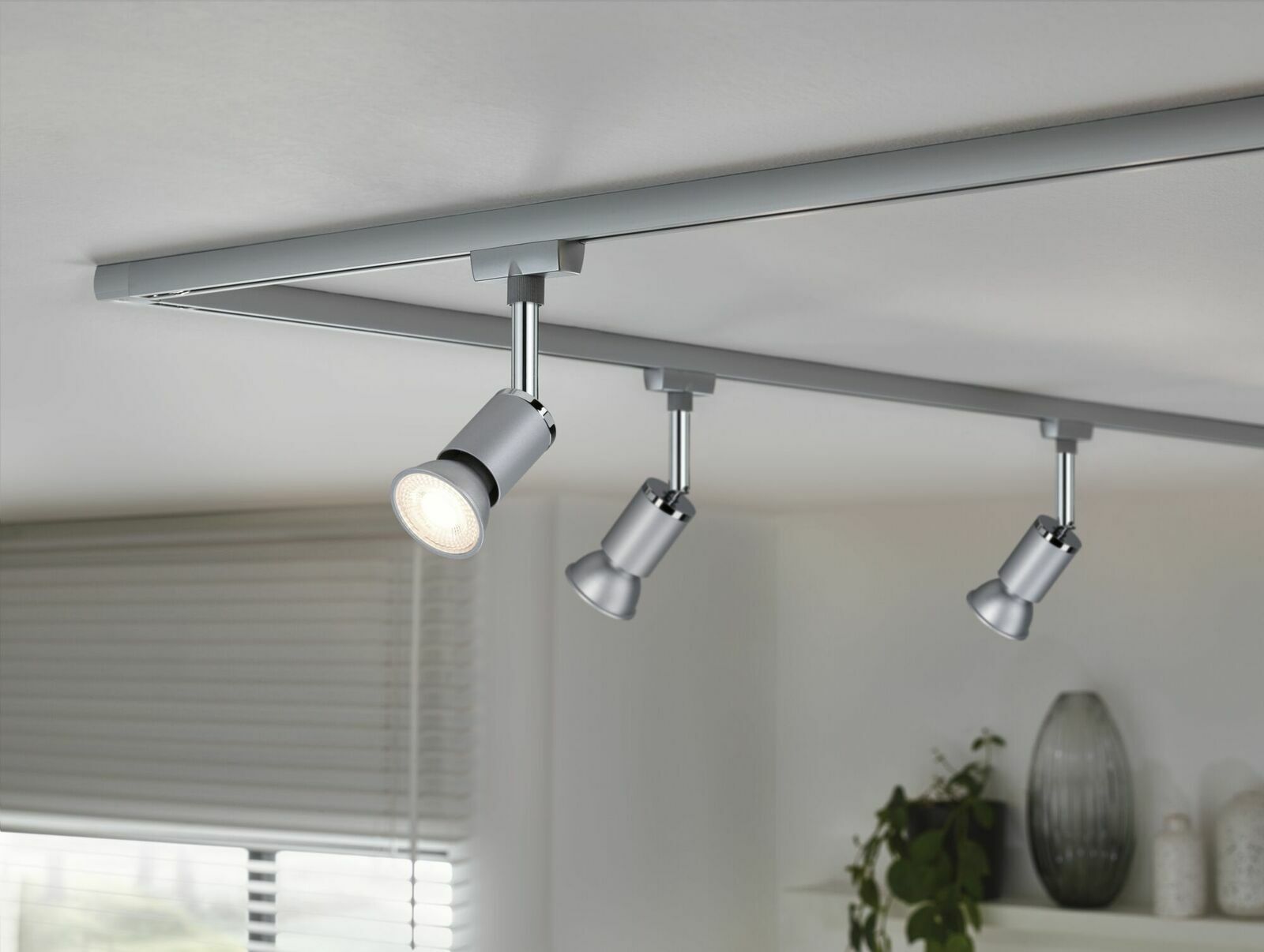 Dreifache LED-Schienenleuchte von Paulmann, montiert an der Decke, mit modernem Design in silberner Farbe, seitliche Perspektive.