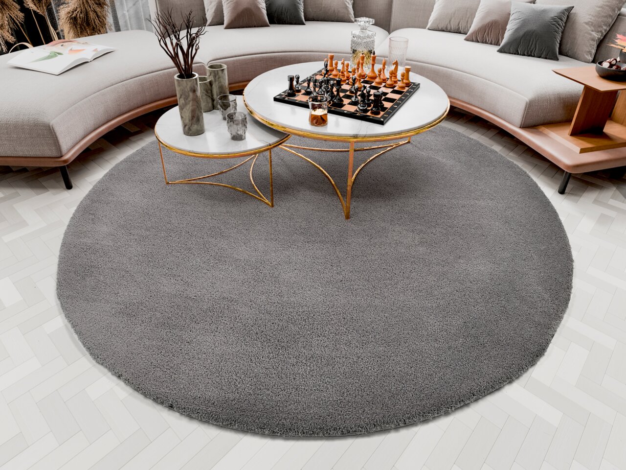 OCI Soft Dream ca. 200cm rund SOFT DREAM Runder grauer Teppich Soft Dream, ca. 200cm, in einem modernen Wohnzimmer mit einem eleganten Couchtisch und einem Schachspiel, von oben betrachtet.
