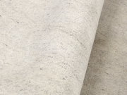 Nahaufnahme eines hellen Wollteppichs mit leicht melierter Textur, von der Seite betrachtet.