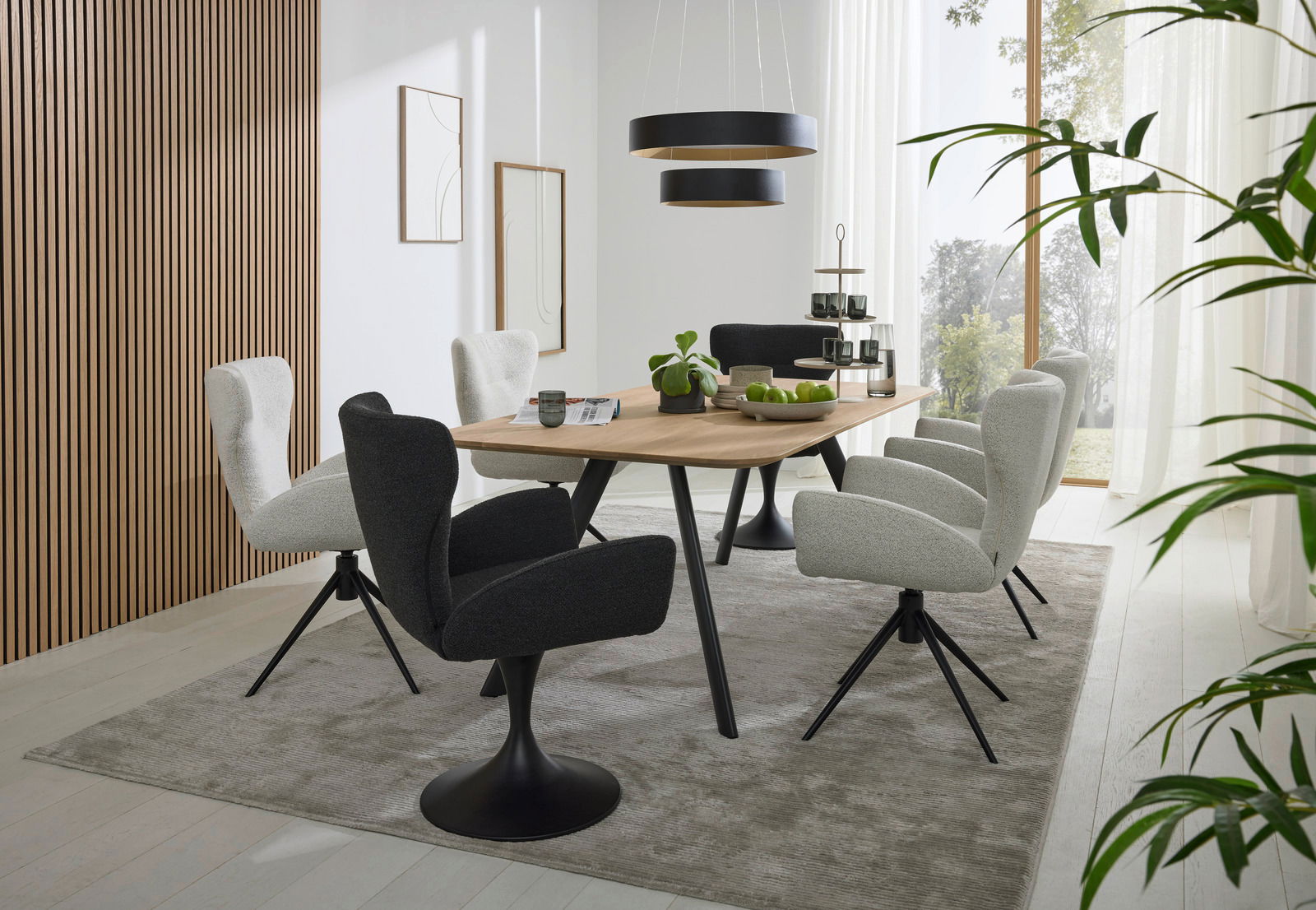 Moderner Essbereich mit einem großen Holztisch und sechs gepolsterten Armlehnstühlen in einem hellen Raum mit großen Fenstern, seitliche Perspektive.