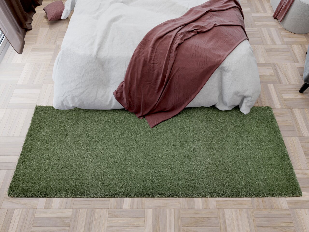 Grüner Teppichläufer vor einem Bett mit weißer Bettwäsche und roter Decke, aus der Vogelperspektive.