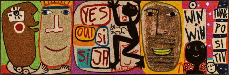 Bunte Fußmatte mit abstrakten Gesichtern und positiven Botschaften aus verschiedenen Perspektiven.