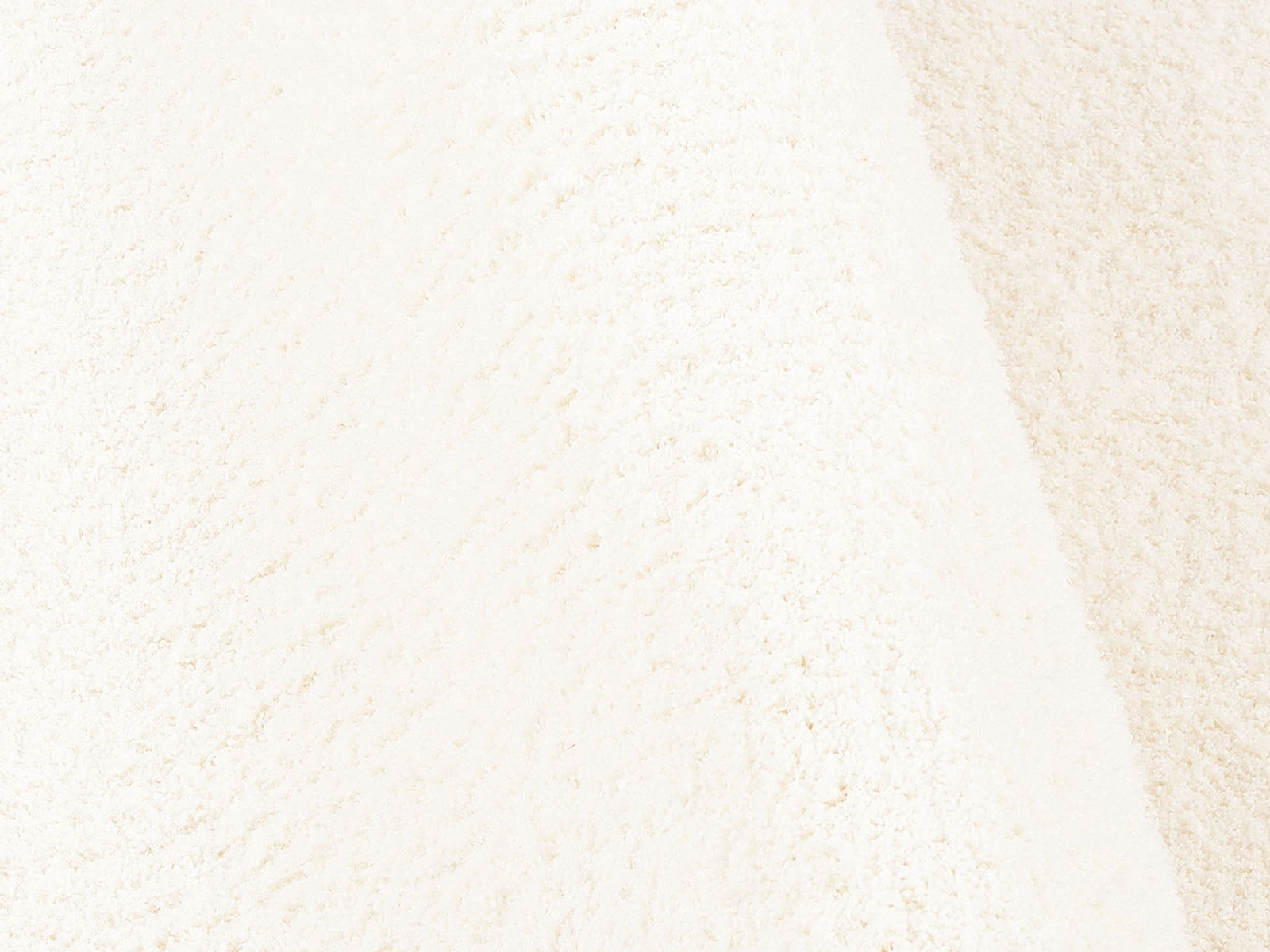 Nahaufnahme einer weichen, cremefarbenen Textur, die die Oberfläche eines Soft Dream Produkts zeigt.