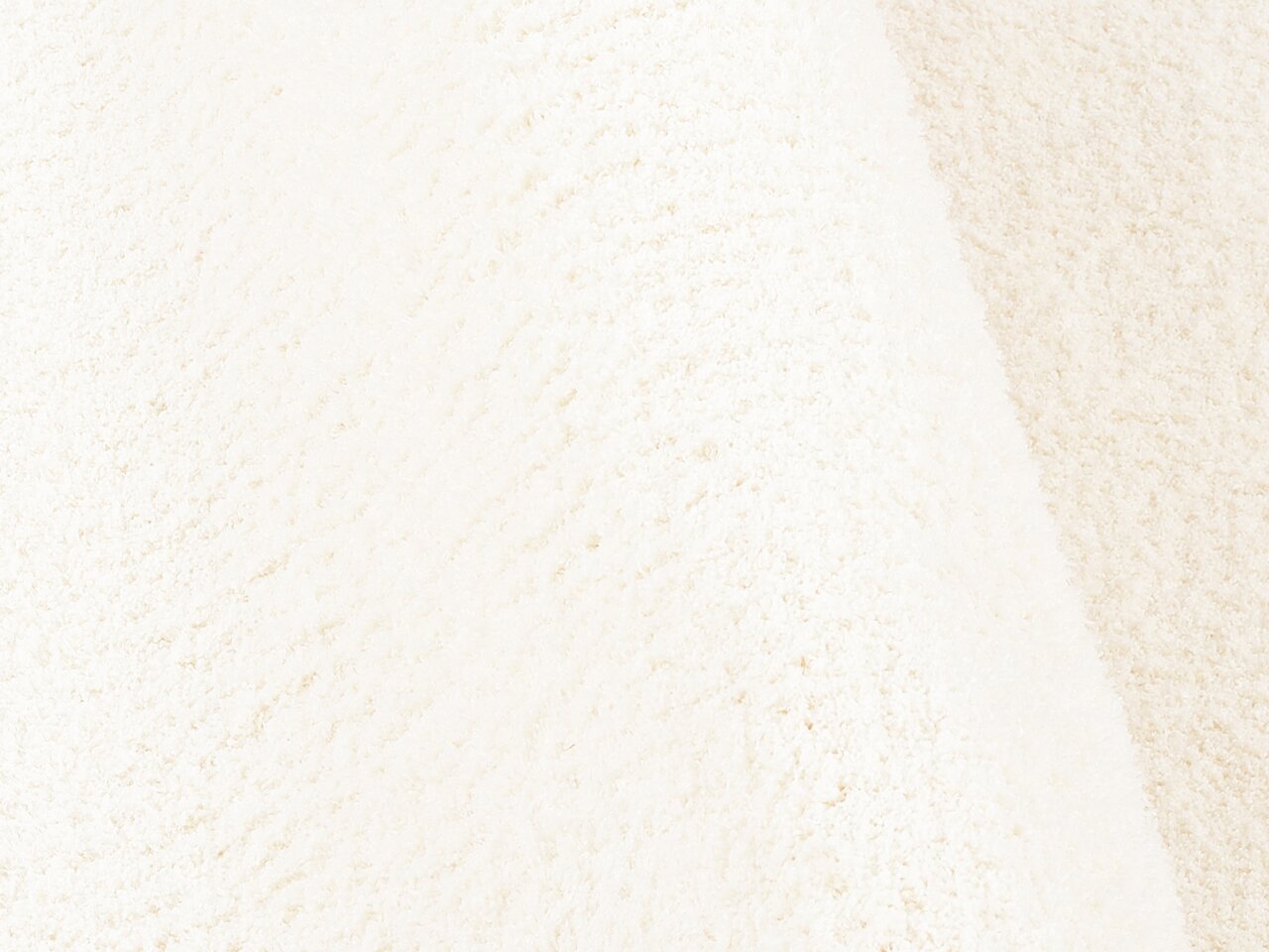 Nahaufnahme einer weichen, cremefarbenen Textur, die die Oberfläche eines Soft Dream Produkts zeigt.