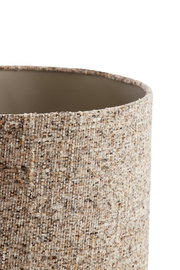 Nahaufnahme eines zylindrischen Lampenschirms mit strukturierter, gewebter Oberfläche in natürlichen Beige- und Brauntönen, seitliche Perspektive