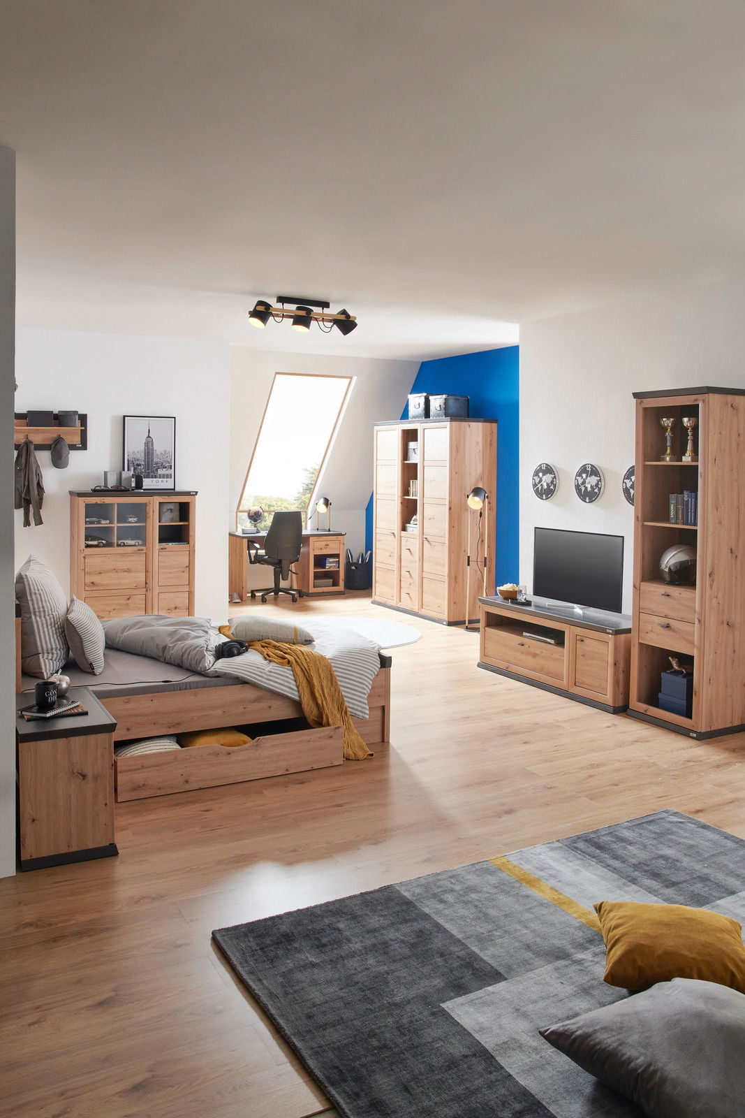 Gemütliches Schlafzimmer mit einem Holzbett 120x200 cm, umgeben von passenden Holzmöbeln, aus der Perspektive eines diagonalen Blicks in den Raum.