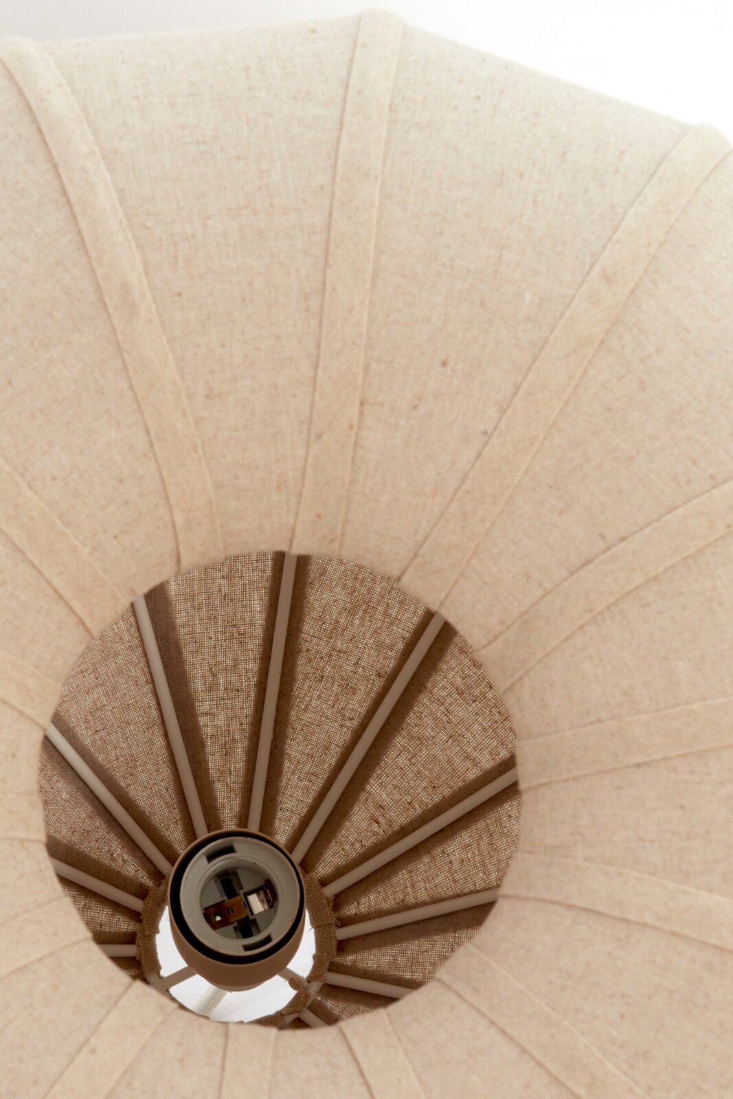 Aanzicht van onderaf op de hanglamp ZUBEDA met een stoffen lampenkap in naturel beige.