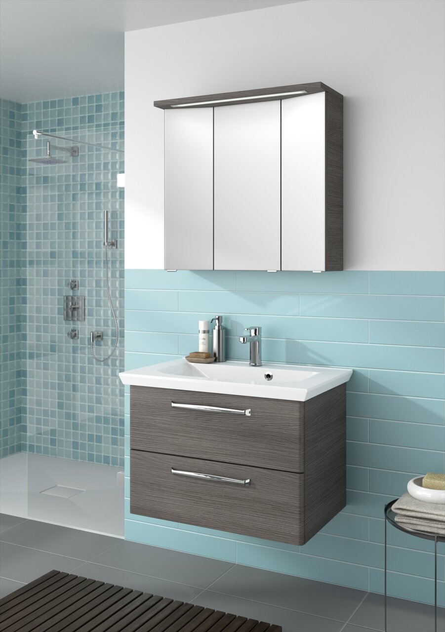 Pelipal Badblock TRENTINO Moderner Badblock mit Spiegelschrank und Waschbecken aus der Frontalperspektive, umgeben von blauen Fliesen.