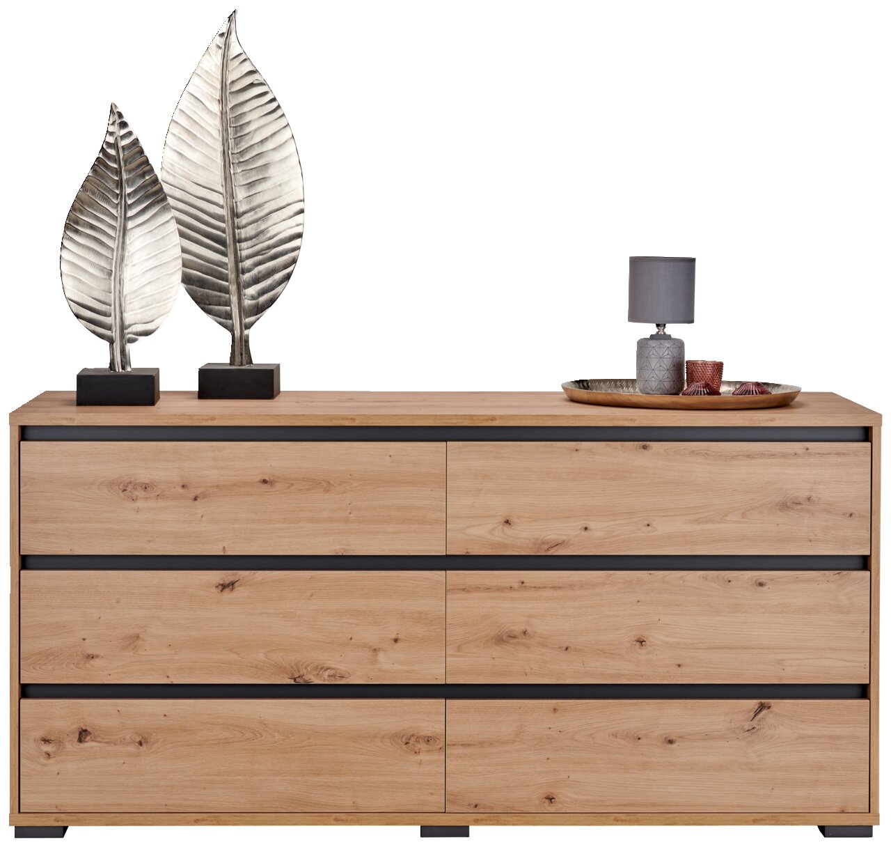 Frontale Ansicht eines XL-Sideboards aus Holz mit sechs Schubladen, dekoriert mit zwei silbernen Blatt-Skulpturen und einer Lampe auf einem Tablett.