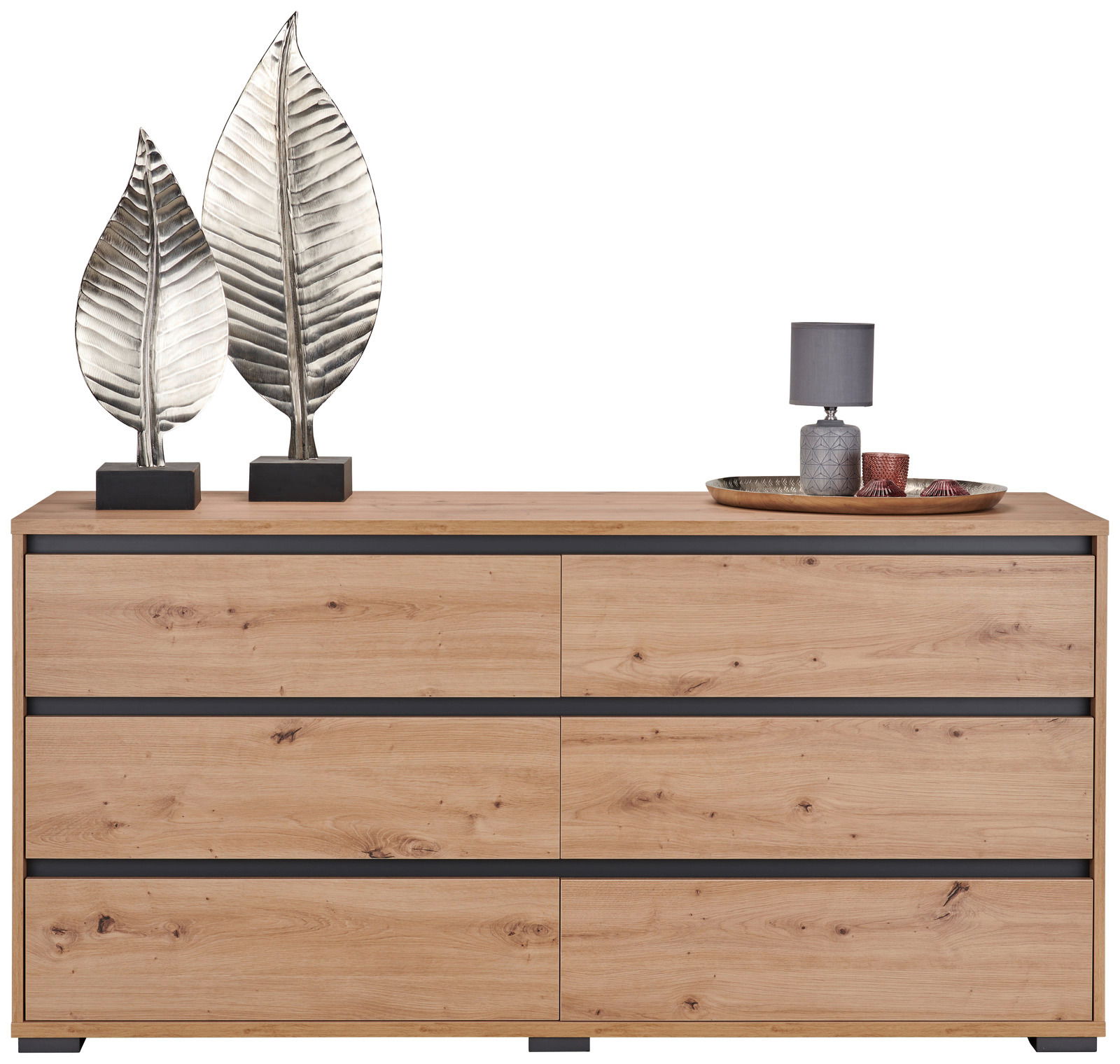 Frontale Ansicht eines XL-Sideboards aus Holz mit sechs Schubladen, dekoriert mit zwei silbernen Blatt-Skulpturen und einer Lampe auf einem Tablett.