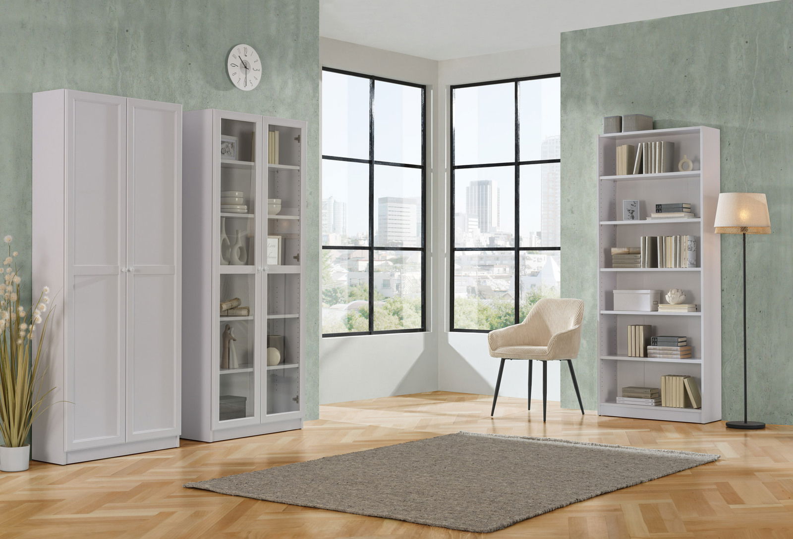 Helle, moderne Wohnzimmer-Einrichtung mit drei weißen Regalen, einem Sessel und einer Stehlampe vor großen Fenstern mit Stadtblick, aus einer leicht seitlichen Perspektive.