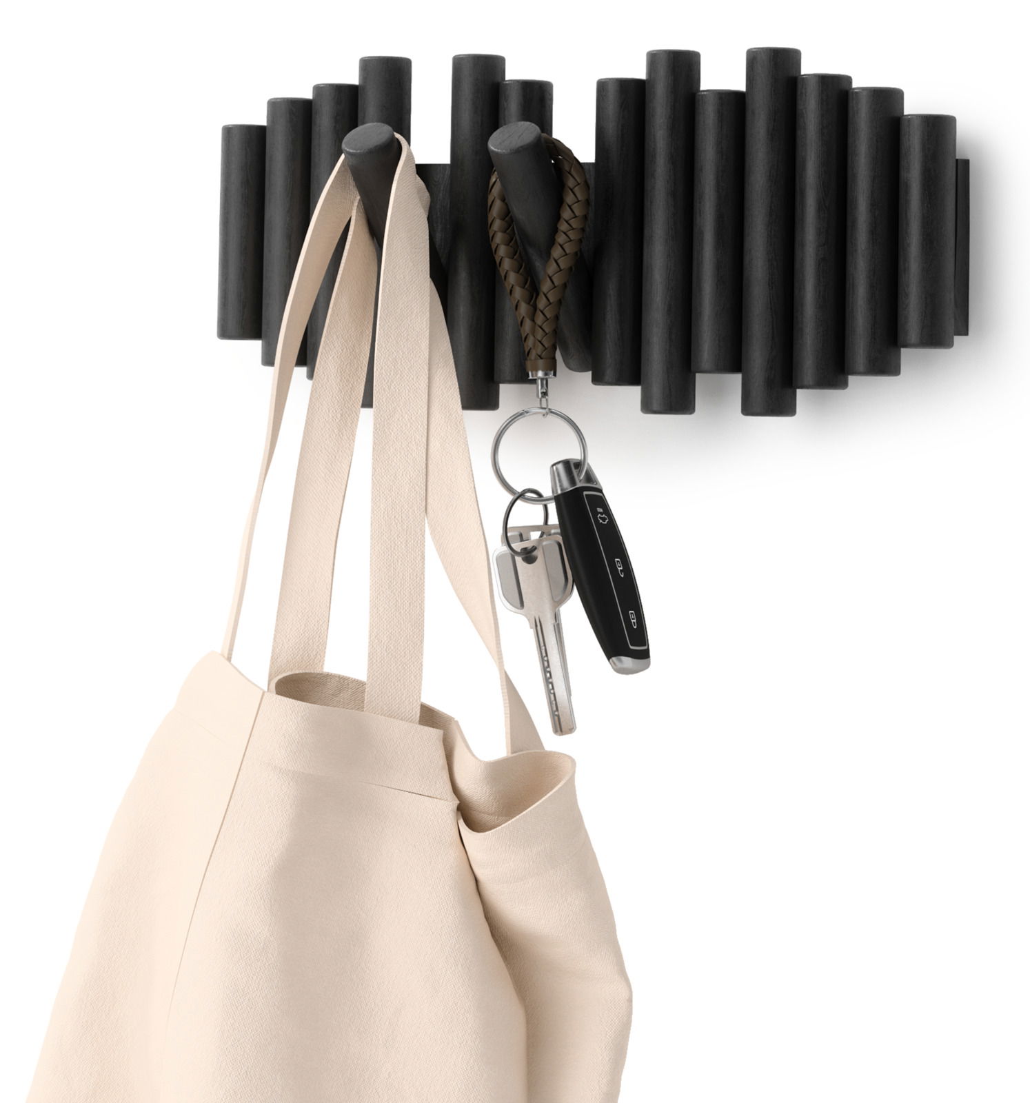 Moderne Wandgarderobe aus dunklem Holz mit Haken, an denen eine Tasche und Schlüssel hängen, seitliche Perspektive