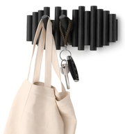 Moderne Wandgarderobe aus dunklem Holz mit Haken, an denen eine Tasche und Schlüssel hängen, seitliche Perspektive