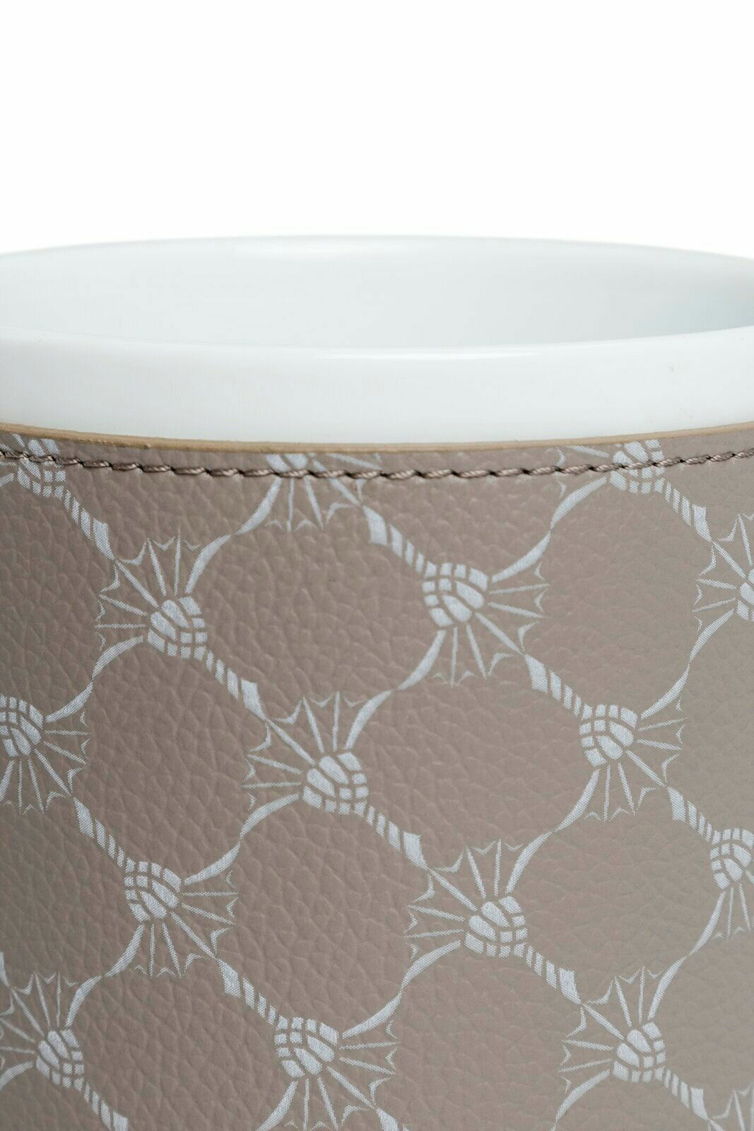 Nahaufnahme eines Porzellanbechers mit grauem, gemustertem Lederüberzug, von oben betrachtet.