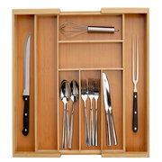 Vogelperspektive auf einen ausziehbaren Besteckkasten aus Holz mit verschiedenen Besteckteilen und Küchenutensilien.