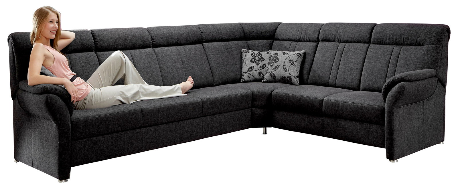 Dunkelgraue Polsterrundecke mit einer Person, die entspannt darauf liegt, seitliche Perspektive.