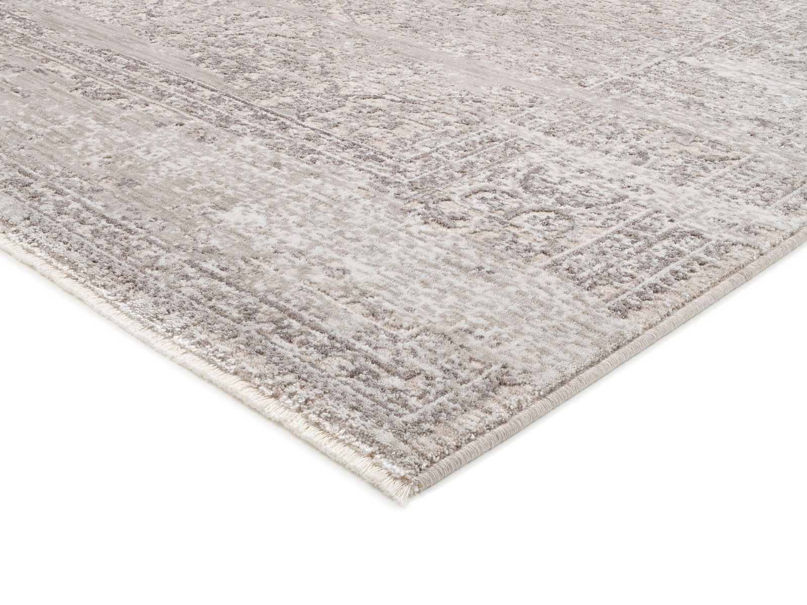 Nahaufnahme eines Designer Teppichs VELA ANTIQUE in Beige- und Grautönen mit antikem Muster, perspektivisch von der Seite aufgenommen.