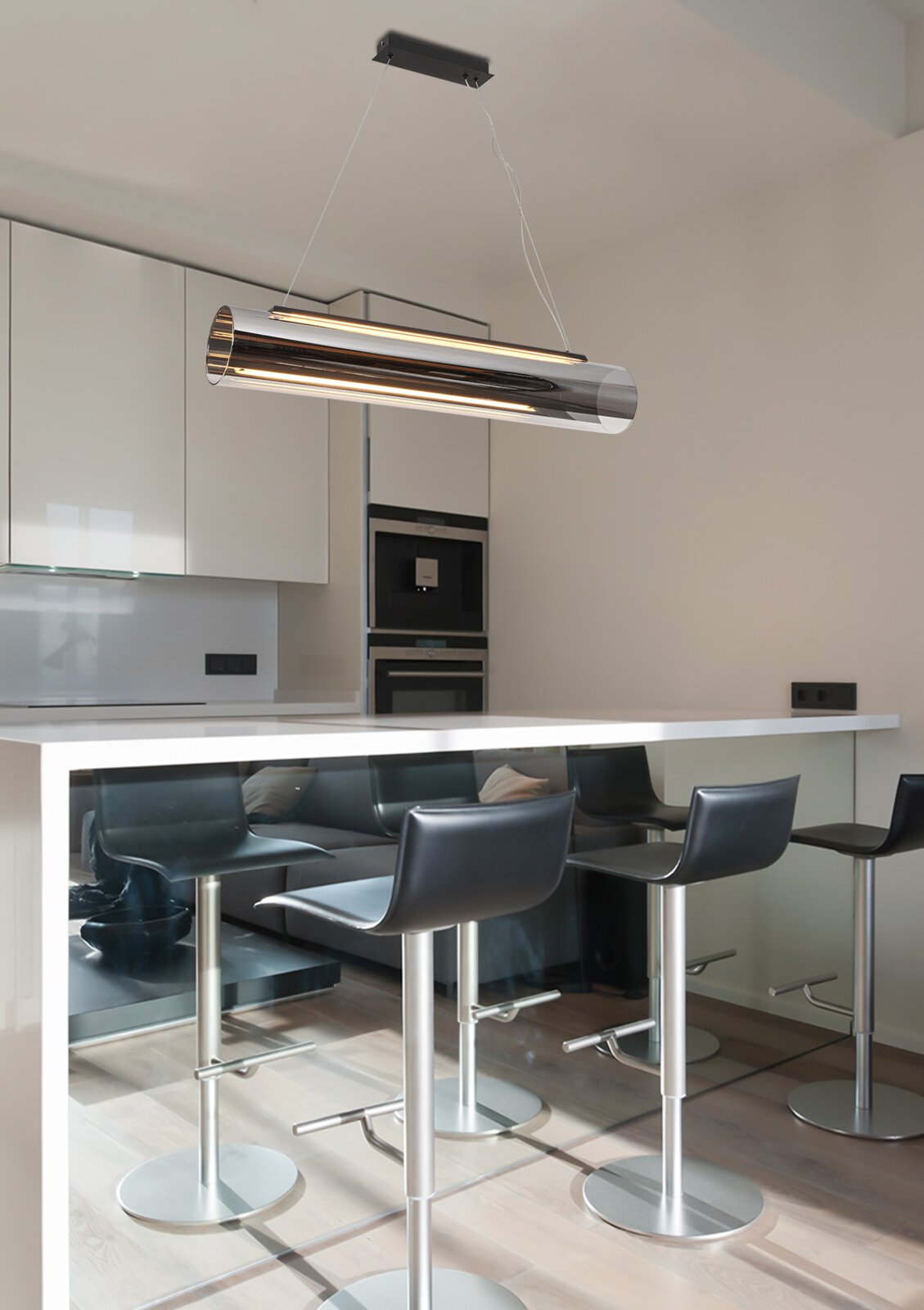 Moderne cilindervormige led-hanglamp boven een kookeiland, gezien vanaf de zijkant.