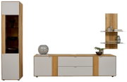Moderne Wohnwand in Eiche-Optik mit hellgrauen Fronten: links hoher Vitrinenschrank mit Glasbereich, mittig breites Lowboard mit Türen und Schubladen, rechts Wandpaneel mit zwei Regalböden; Frontansicht/gerade Perspektive.