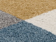 Nahaufnahme eines Uni-Teppichs mit geometrischem Muster in Blau, Grau, Beige und Weiß.