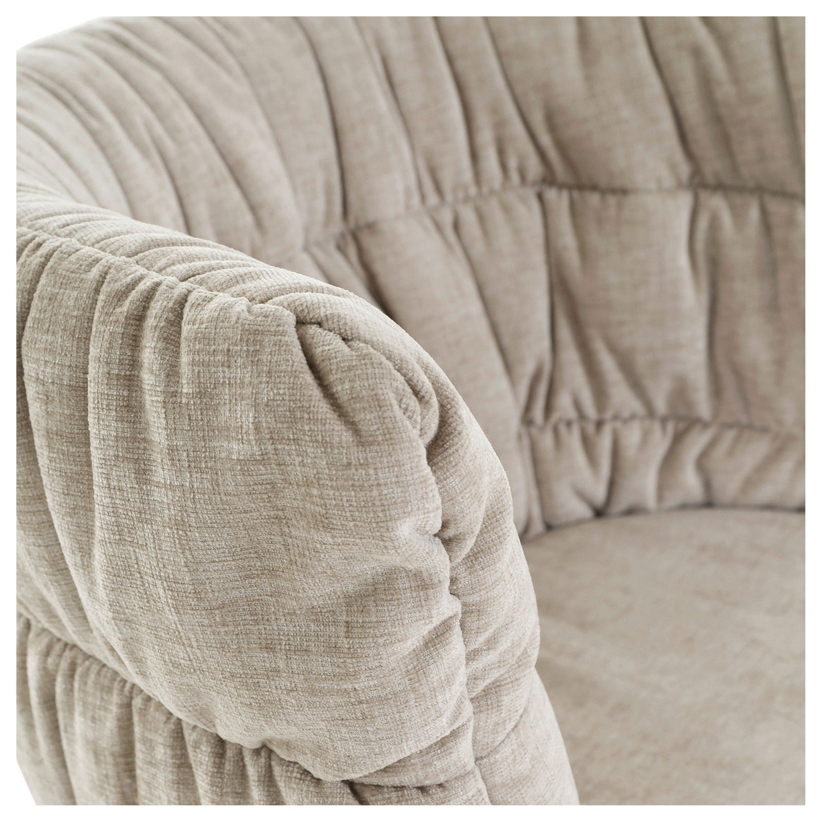 Nahaufnahme eines beigen Armlehnstuhls mit weicher Polsterung und texturierter Oberfläche, seitliche Perspektive.