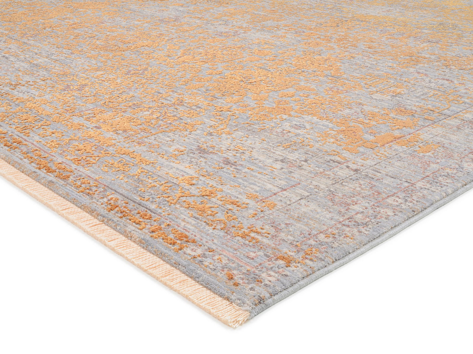 Designer Teppich in Nahaufnahme, zeigt eine Mischung aus goldenen und grauen Tönen mit einem strukturierten Muster, perspektivisch von der Ecke aufgenommen.