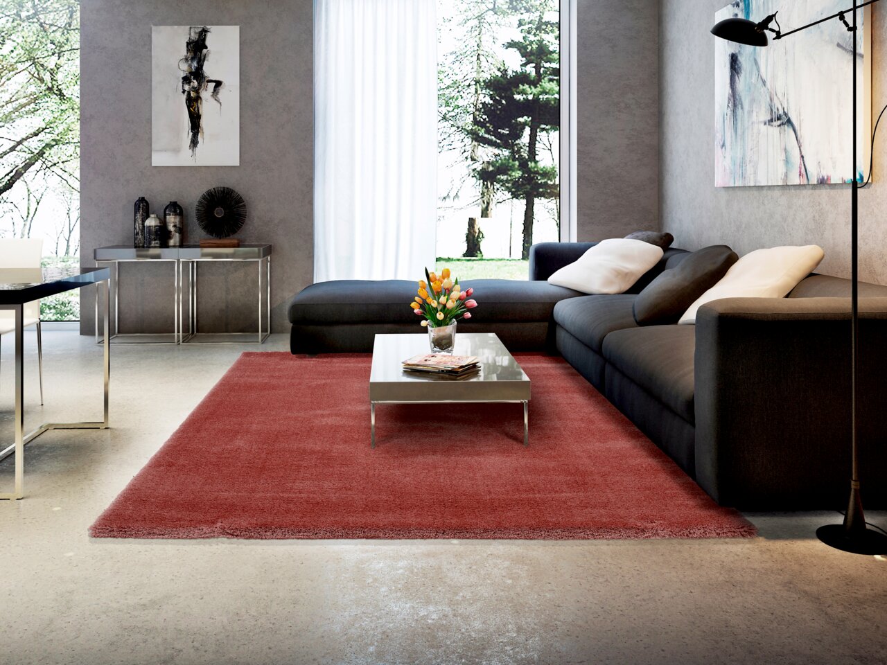 OCI Tapijt 240 x 290 cm SOFT DREAM Moderner Wohnraum mit großem, weinrotem Teppich, der zentral vor einer grauen Eckcouch liegt. Der Raum ist stilvoll eingerichtet mit einem Couchtisch aus Metall und Glas, dekorativen Kissen und Kunstwerken an den Wänden. Große Fenster bieten einen Blick i