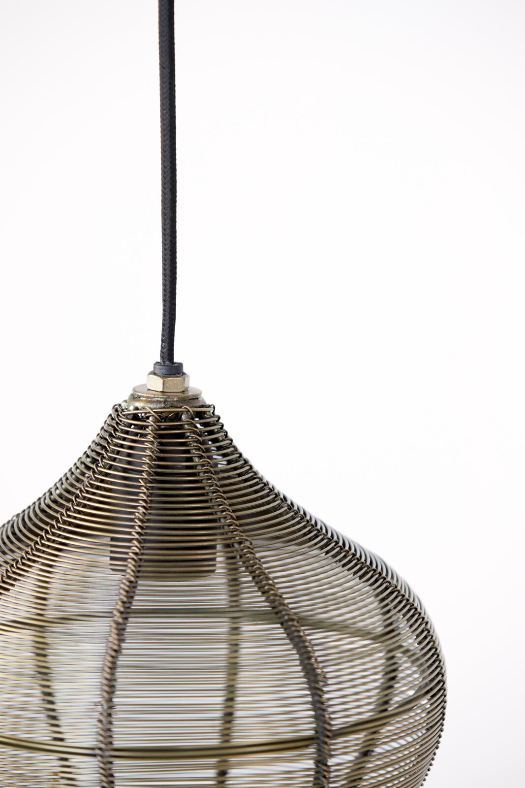 Close-up van een hanglamp met een decoratieve, uit draad gewikkelde kap, gezien van bovenaf.
