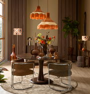 Moderner Armlehnstuhl mit braunem Stoffbezug und verchromtem Gestell, seitliche Perspektive in einem stilvoll eingerichteten Esszimmer.