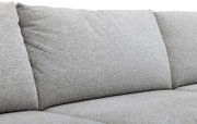 Detailansicht von vorne auf die weich gepolsterten Rücken- und Sitzkissen eines hellgrauen Sofas mit fein strukturierter Stoffoberfläche