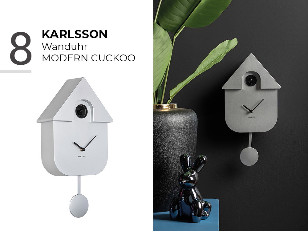 Moderne Kuckucksuhr „Modern Cuckoo“ von Karlsson in Grau, dekorativ aufgestellt neben Pflanze