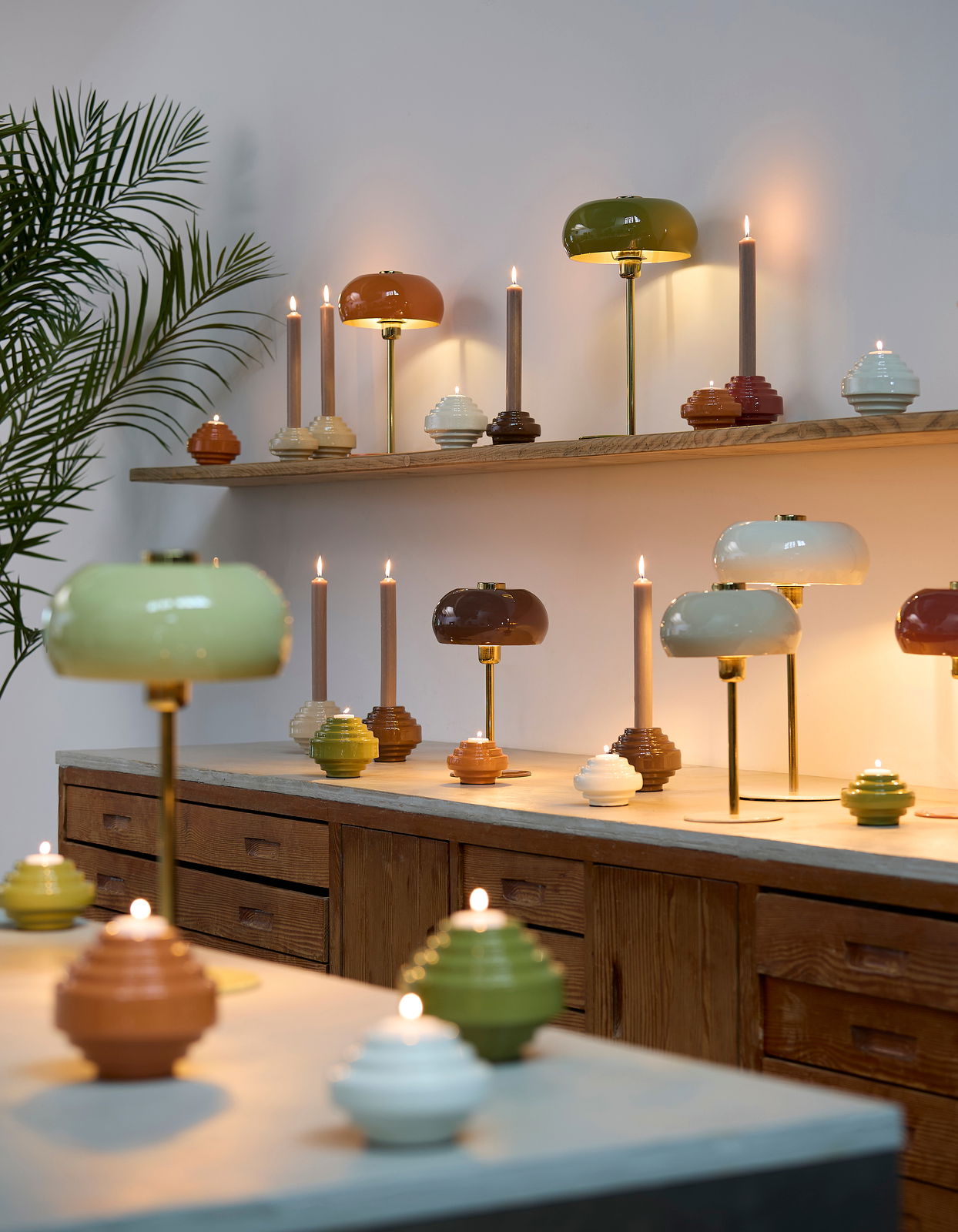 Light&Living Tafellamp SURIN Mehrere Tischleuchten in verschiedenen Farben und Formen auf einem Regal und Tisch, seitliche Perspektive.