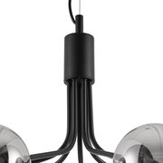 Nahaufnahme einer modernen Hängeleuchte mit schwarzen Metallarmen und glänzenden Kugeln, von unten betrachtet.