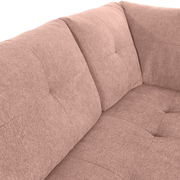 Nahaufnahme einer rosafarbenen Rundecke mit weichem Stoffbezug und gepolsterten Kissen, Blick auf die Ecke des Sofas.